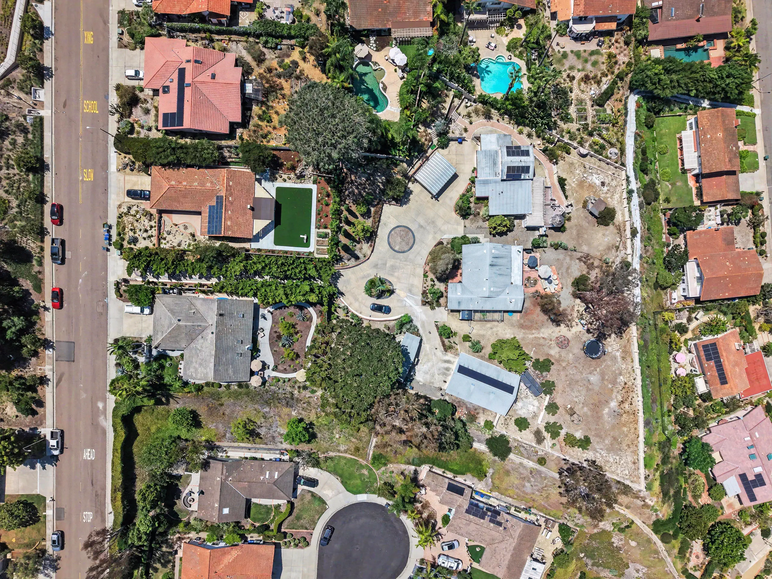 Overhead aerial of the parcel showing the motor court, both residences, outbuildings and the cleared ground.