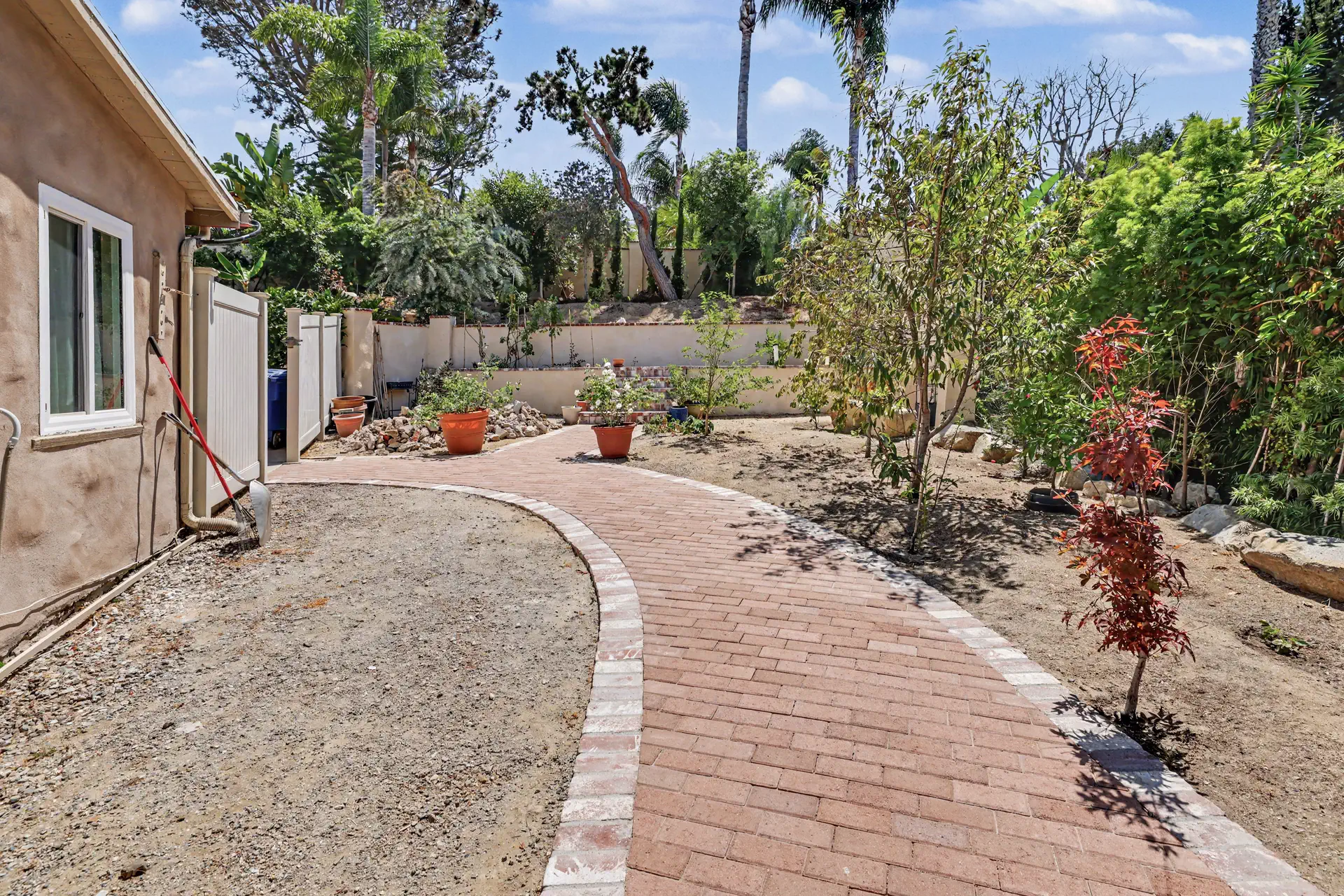 A brick path curving through a planted border alongside the residence.