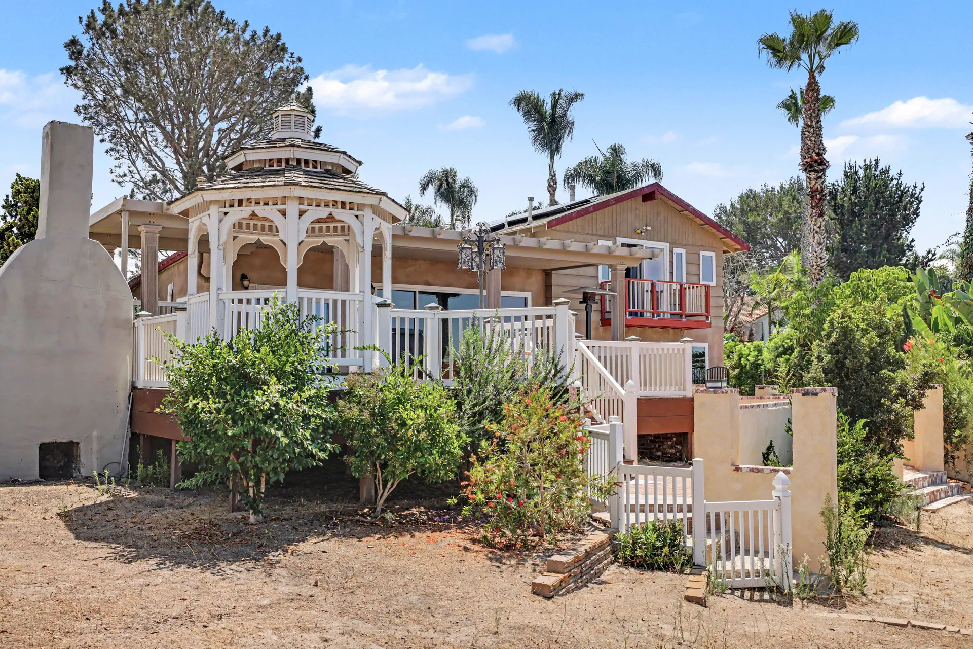 The gazebo and the main residence seen across open ground.