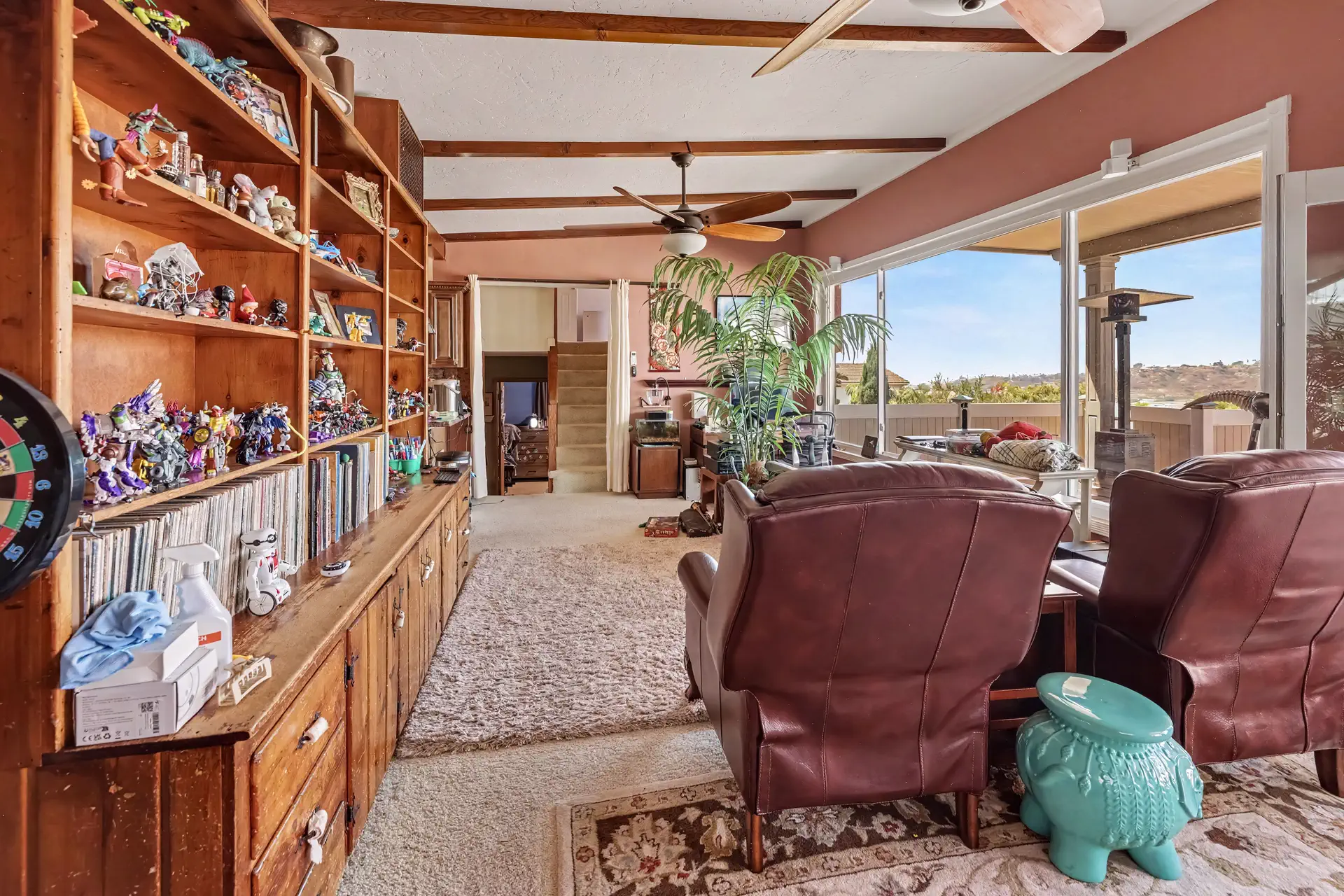 Living room of the existing residence with timber built-ins, photographed in its current occupied condition.