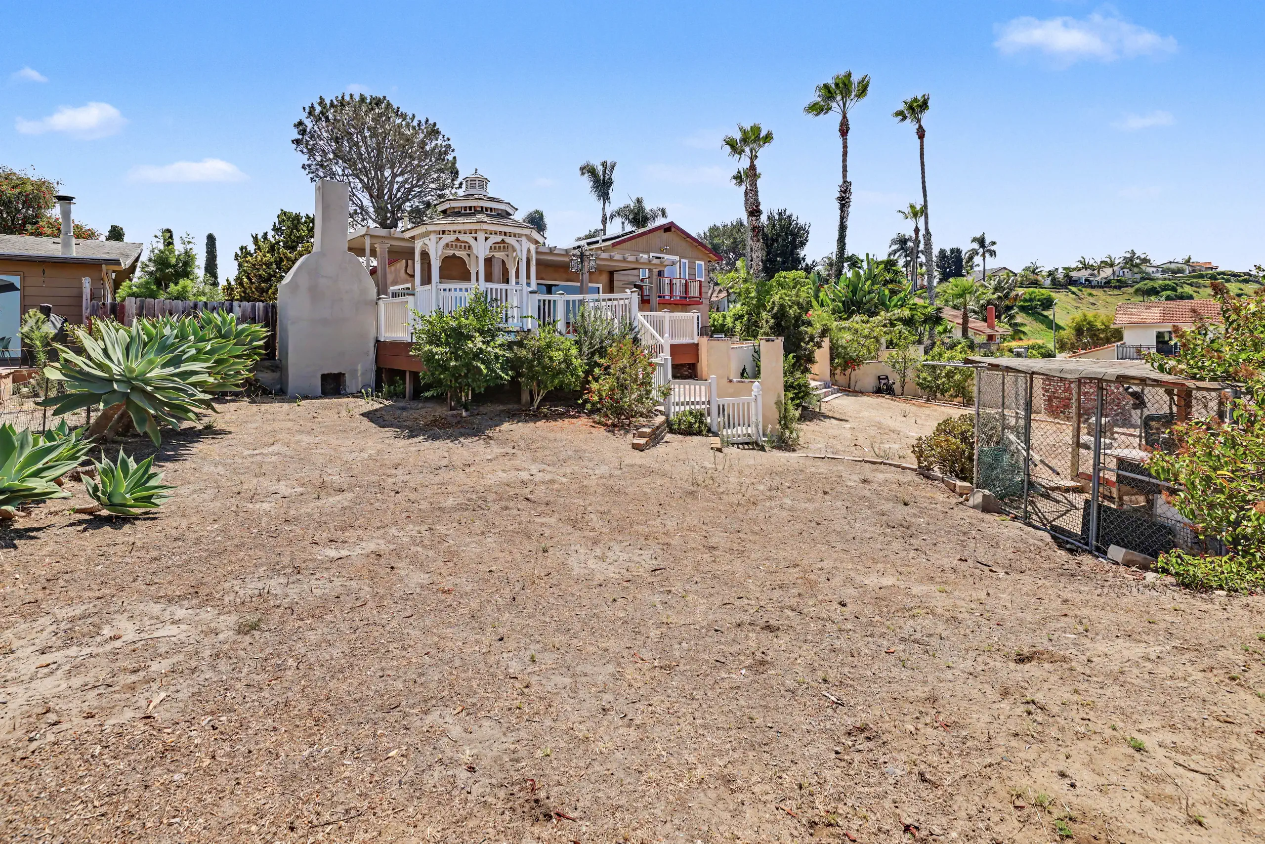 Wide expanse of level, cleared ground across the center of the parcel with the residence beyond.