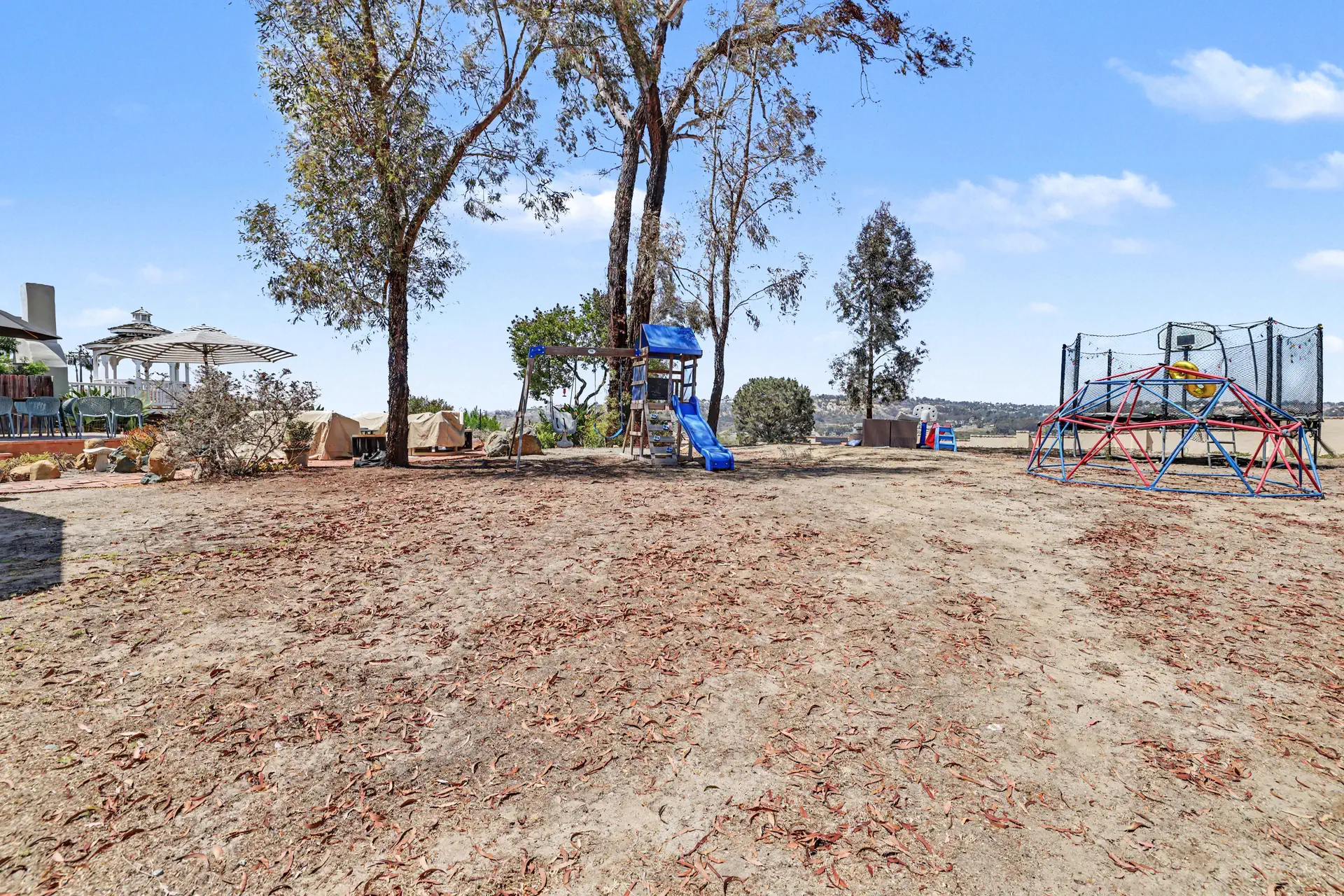 The broad southern pad, level and cleared, under a stand of mature trees.