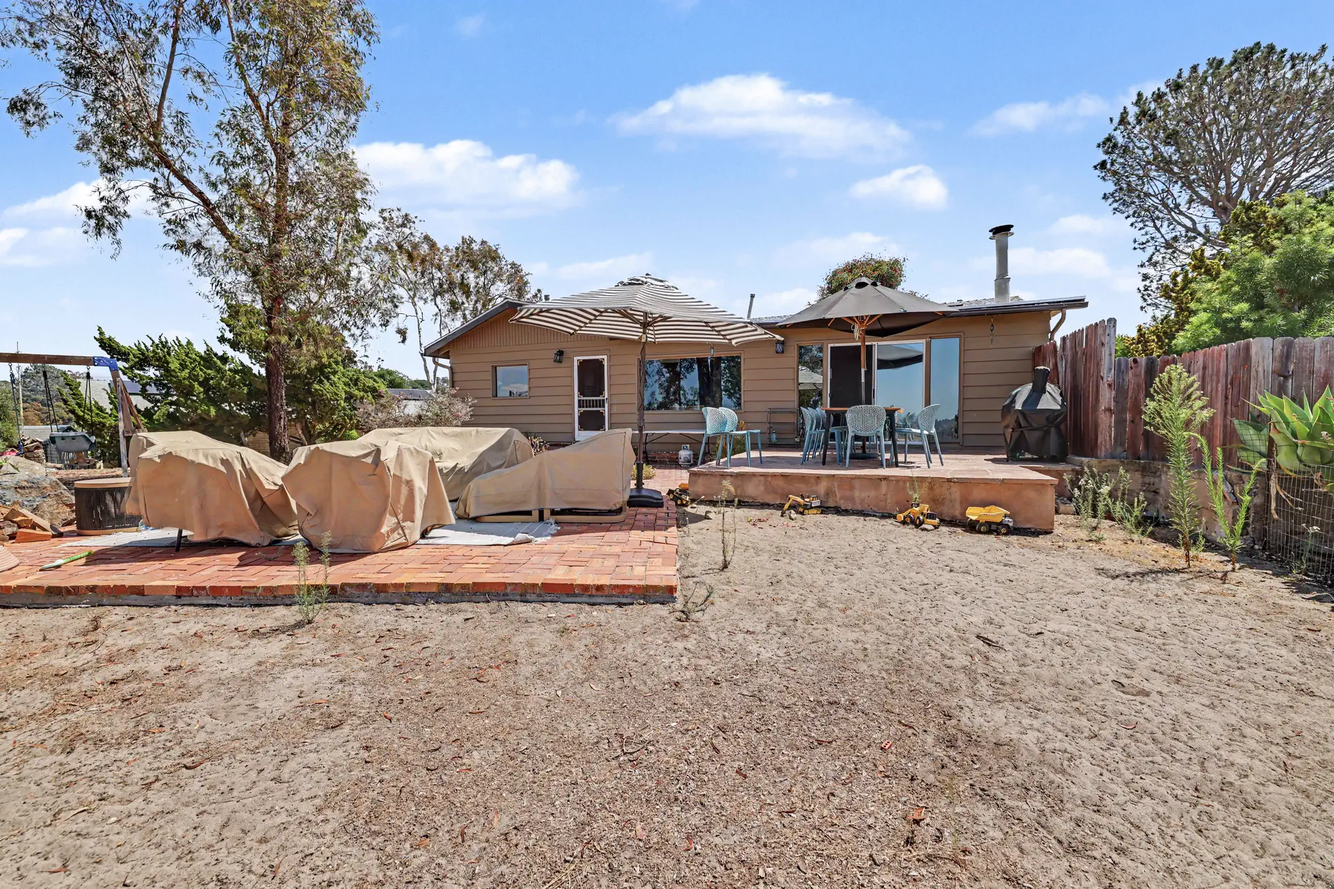 Patio and open cleared ground behind the second residence.