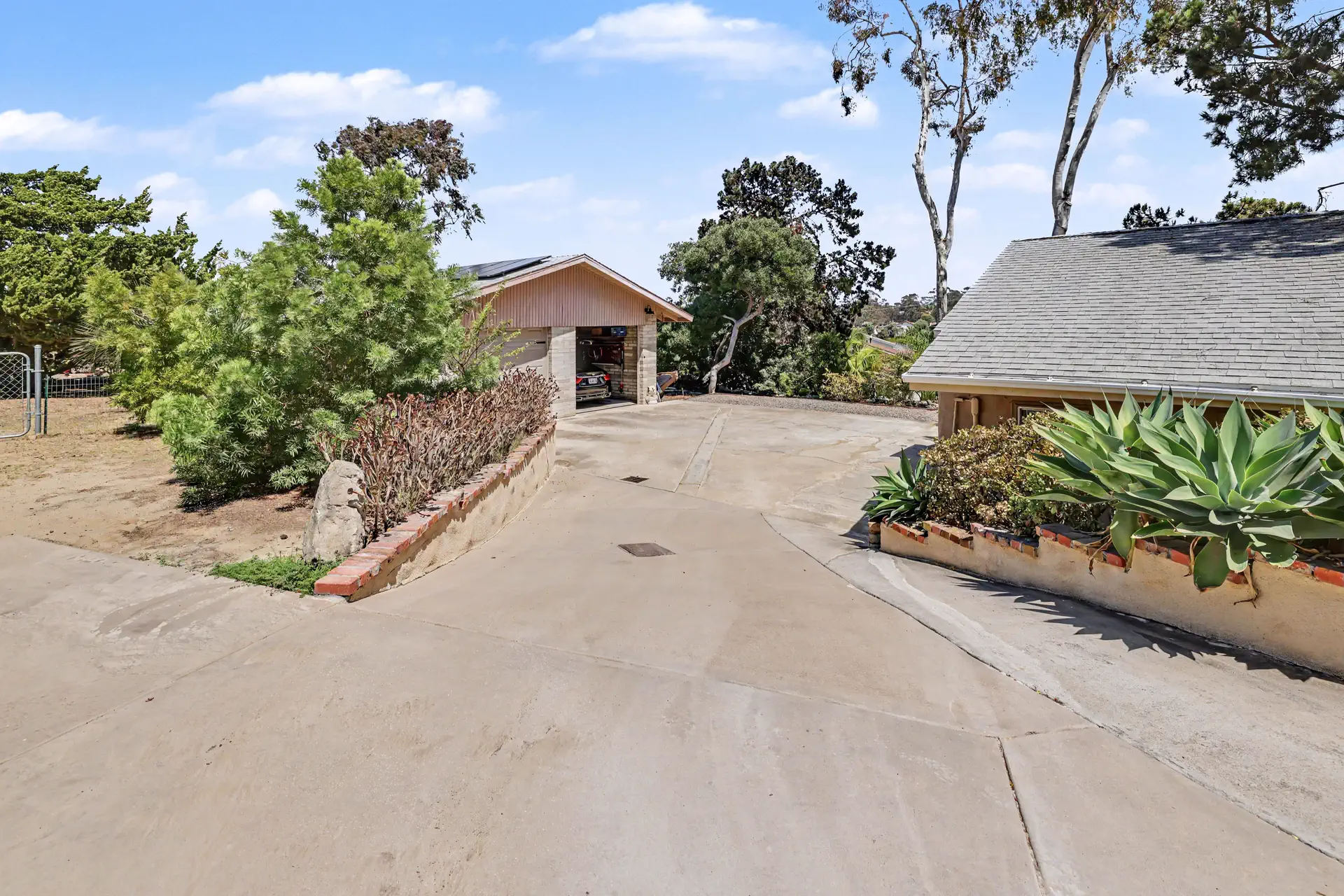 The upper drive and an outbuilding beneath eucalyptus.